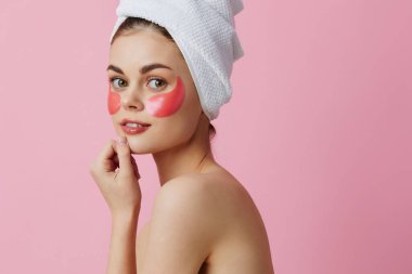 Kafasında pembe bir havluyla yüzünde pembe lekeler olan genç bir kadın.