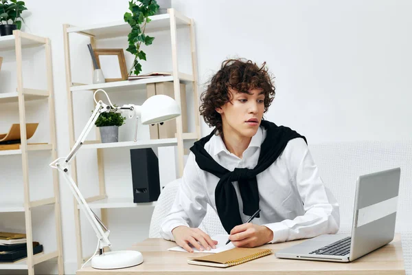 Cara sentado no sofá na mesa na frente de uma sala de estar laptop — Fotografia de Stock