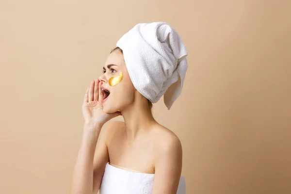 Kvinna med en handduk på huvudet gester med händerna hudvård isolerad bakgrund — Stockfoto