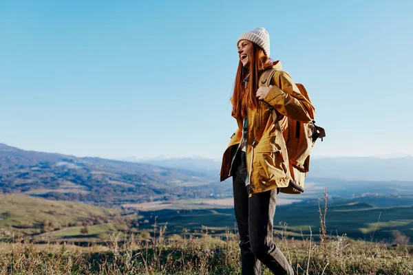 Mulher turista em uma jaqueta amarela em uma mochila chapéu viagens montanhas relaxamento — Fotografia de Stock