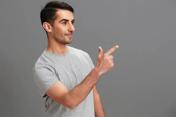 Yakışıklı adam eğlenceli gri tişört el hareketi izole edilmiş arka plan — Stok fotoğraf