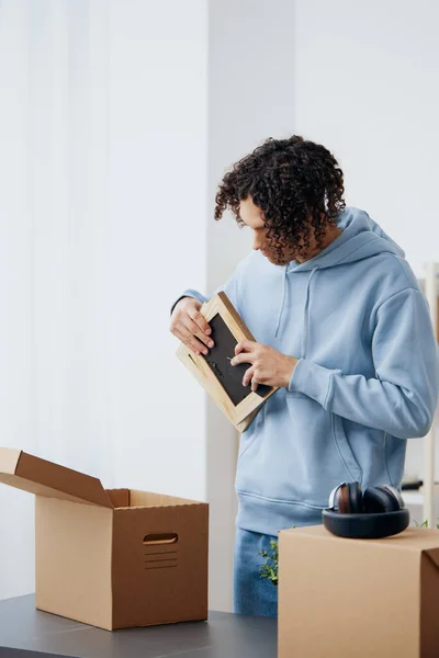 Ein junger Mann Pappkartons im Raum beim Auspacken — Stockfoto