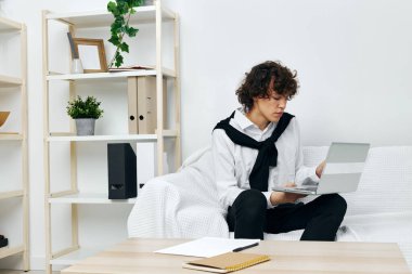 Adam dizüstü bilgisayarı beyaz koltukta oturuyor çevrimiçi yaşam tarzı eğitimi alıyor.