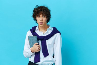 Omuzlarında süveter tişörtü olan, arka planda izole edilmiş not defteri olan bir adam.