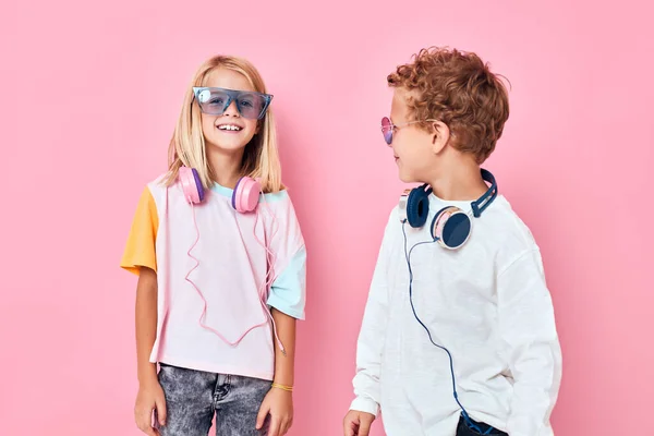 Модний хлопчик і дівчина в сонцезахисних окулярах розважаються з друзями випадкові діти мода — стокове фото