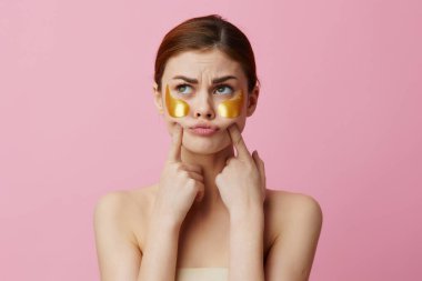 Pembe arka planda cilt bakımı yamaları olan güzel bir kadın. Yüksek kalite fotoğraf