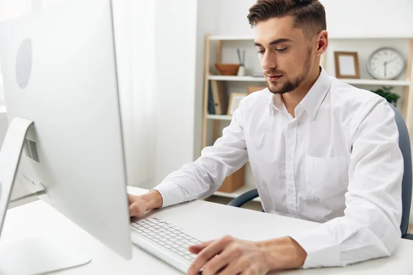 Gestionnaire assis à un bureau en face d'un ordinateur avec un clavier technologies — Photo