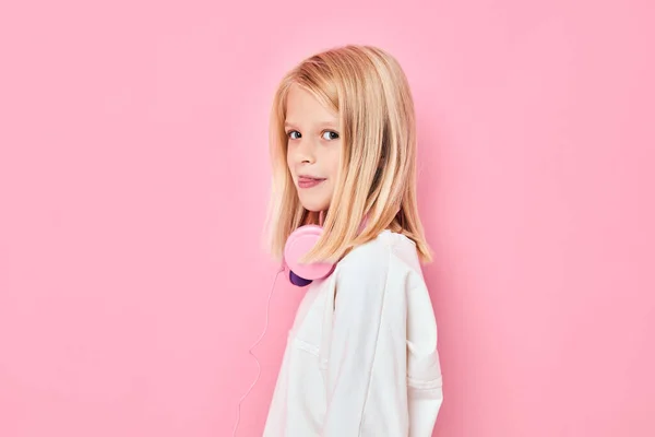 Schattig meisje blond haar hoofdtelefoon poseren roze achtergrond — Stockfoto
