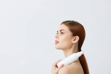 Geçmişinde losyon kavanozu olan genç bir kadın. Yüksek kalite fotoğraf