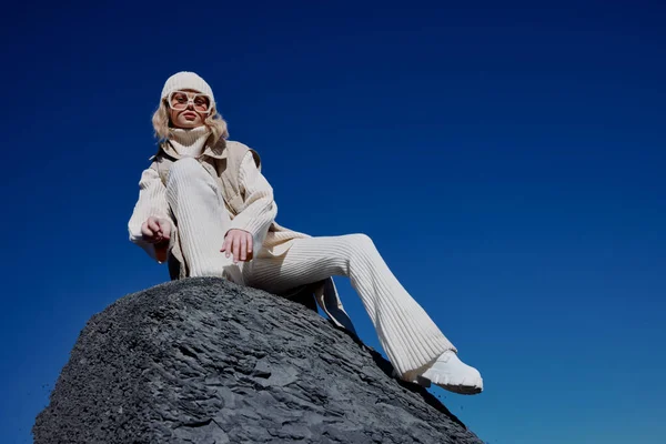 Turysta siedzi na kamiennej przyrody błękitne niebo w kapeluszu relaks — Zdjęcie stockowe