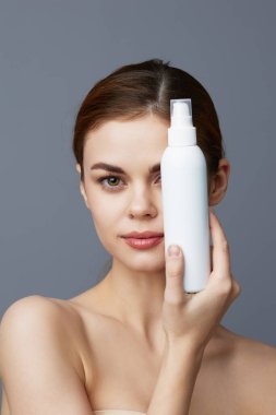 Çıplak omuzlu güzel kadın cilt bakım losyonu. Yakın çekim yaşam tarzı.