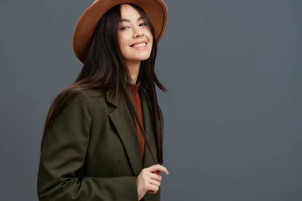 Mujer bonita en un traje con un sombrero posando ropa casual fondo gris — Foto de Stock