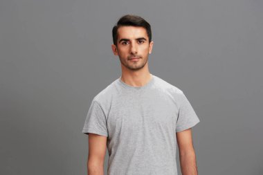 Neşeli adam yaşam tarzı pozu veren güler yüzlü stüdyo gri arka plan