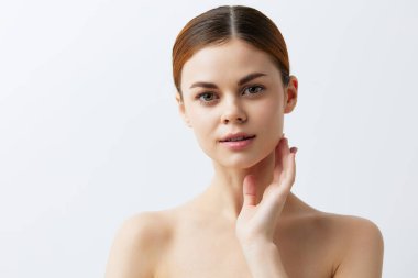 Genç bir kadın, temiz cilt bakımı pozu veriyor. Çekici görünüyor.