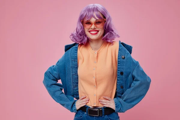 Abbastanza giovane abbigliamento denim femminile moda in posa cap occhiali rosa sfondo di colore inalterato — Foto Stock
