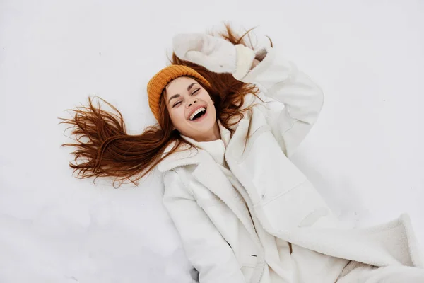 Vrolijke vrouw winter kleding met een hoed ligt op de sneeuw Lifestyle — Stockfoto