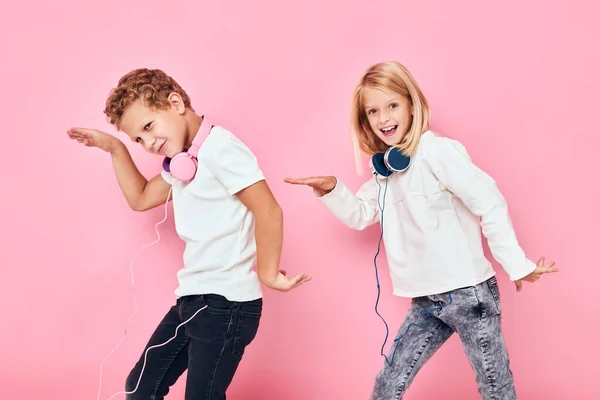 Chlapec a dívka stojí vedle ve sluchátkách studio dětství — Stock fotografie