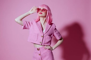 Pozitif, genç bir kadın, elleri pembe ceketli, cazibeli, tek renkli, değişmez bir fotoğraf.
