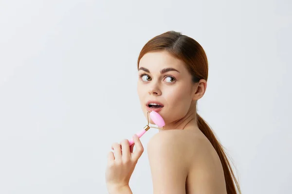 Junge Frau rosa Quarzroller Hautpflege Massage nackte Schultern Nahaufnahme Lifestyle — Stockfoto