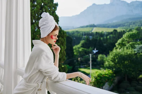 Mulher retrato em um manto branco a varanda com vista para as montanhas inalterada — Fotografia de Stock