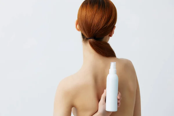 Loción para el cuidado de la piel de mujer con hombros desnudos fondo aislado —  Fotos de Stock