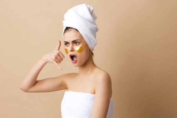 Retrato mujer parches rejuvenecimiento cuidado de la piel diversión después de la ducha fondo beige — Foto de Stock