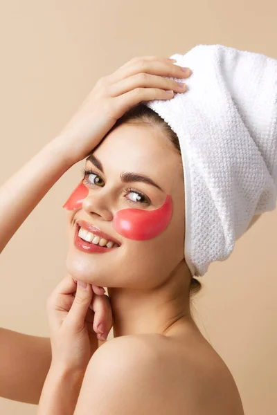 Mujer parches de color rosa en la cara con una toalla en la cabeza fondo aislado — Foto de Stock