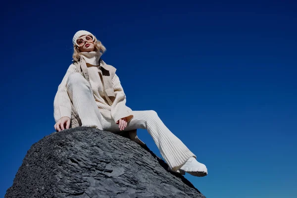 Mujer en la ropa de otoño se encuentra en un paisaje de roca azul cielo estilo de vida —  Fotos de Stock