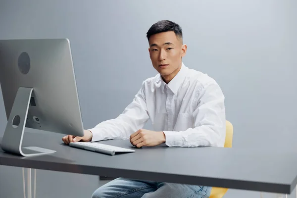 Homem senta-se em um computador no escritório com um teclado isolado fundo — Fotografia de Stock