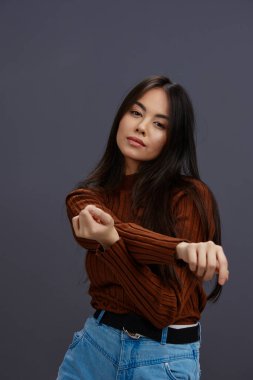 Güzel kadın el hareketleri kahverengi süveter giysisi gri arka plan