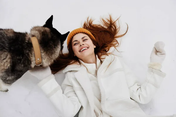 Ritratto di una donna nella neve che gioca con un cane divertente amicizia vacanze invernali — Foto Stock