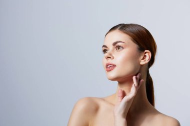 Güzel bir kadın. Kızıl saçlı, çıplak omuzlu. Kozmetik cilt temizleyicisi.