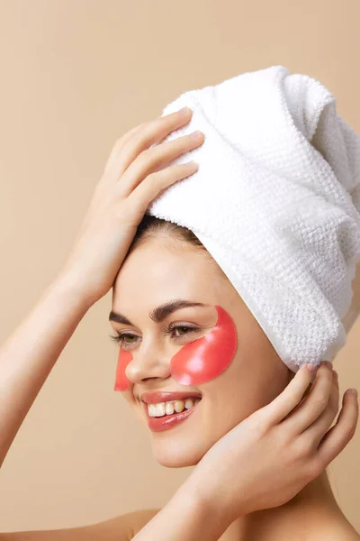 Mujer parches de color rosa en la cara con una toalla en la cabeza fondo aislado — Foto de Stock