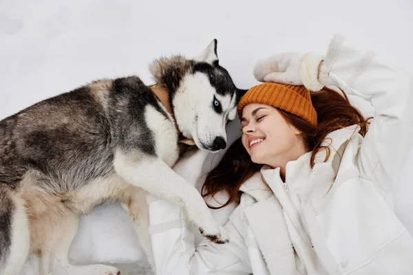 Mladá žena ve sněhu hrát se psem zábava přátelství životní styl — Stock fotografie