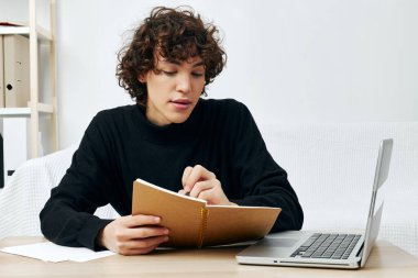 Dizüstü bilgisayarın önünde beyaz koltukta oturan bir adam yaşam tarzı teknolojisini öğreniyor.