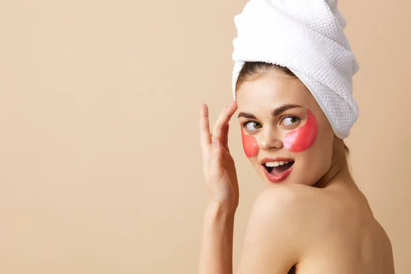 Vacker kvinna rosa fläckar i ansiktet med en handduk på huvudet beige bakgrund — Stockfoto