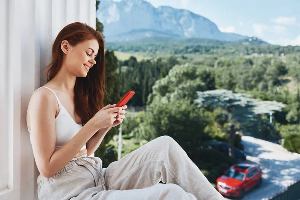 Mulher alegre sentado na varanda com telefone bela vista montanha verão Mountain View — Fotografia de Stock