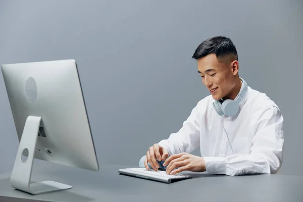 Gerente em uma camisa branca com fones de ouvido senta-se no trabalho de estilo de vida escritório — Fotografia de Stock