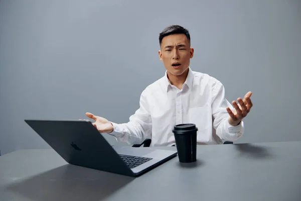 Uomini d'affari affaticamento emozioni laptop lavoro caffè al desktop sfondo grigio — Foto Stock