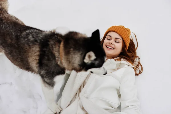 Χαρούμενη γυναίκα στο χιόνι παίζει με ένα σκυλί διασκέδαση φιλία χειμερινές διακοπές — Φωτογραφία Αρχείου
