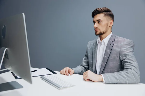 Hommes d'affaires en costume gris assis devant un ordinateur isolé arrière-plan — Photo