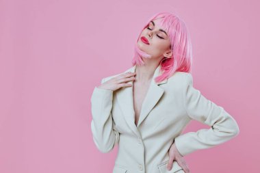 Takım elbiseli, makyajlı, pembe saçlı, rengini değiştirmemiş güzel bir kadın.