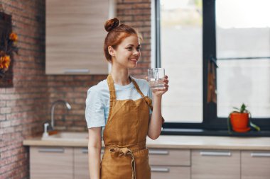 Mutfakta kahverengi önlüklü güzel bir kadın. Yüksek kalite fotoğraf