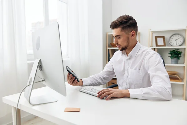 Gestionnaire assis à un bureau devant un ordinateur avec un poste de travail clavier — Photo