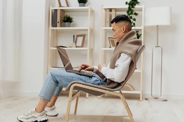 Asiatico uomo casa con computer portatile in sedia interno internet stile di vita lavoro — Foto Stock