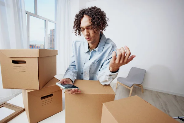 Schöner Kerl Kartons im Zimmer Auspacken mit Handy-Interieur — Stockfoto