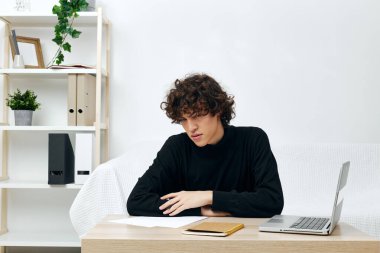 Kıvırcık adam internette dizüstü bilgisayar öğreniyor. Ev içi iletişim.