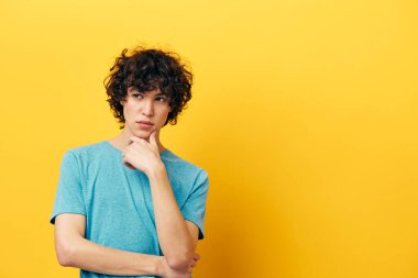 Kıvırcık çocuk yaşam tarzı stüdyo sarı arka plan pozu veriyor.