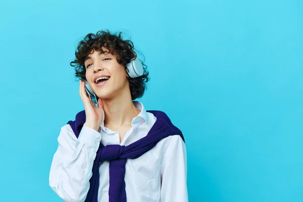 Kudrnatý chlap technologie sluchátka v bílé košili se svetrem životní styl školy — Stock fotografie