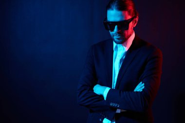 Yakışıklı adam modern tarz takım elbise güneş gözlüğü neon ışık
